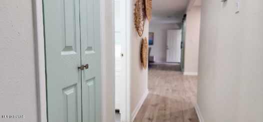 hallway with baseboards and light wood-style floors