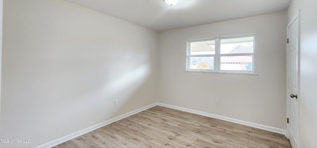 empty room featuring light wood-style flooring and baseboards