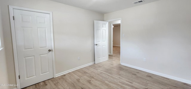 unfurnished bedroom featuring baseboards, visible vents, and light wood finished floors