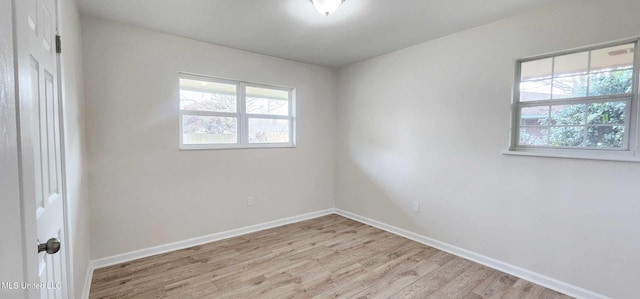 empty room featuring light wood-type flooring and baseboards