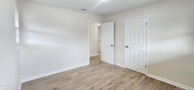 unfurnished bedroom with light wood-type flooring, visible vents, and baseboards