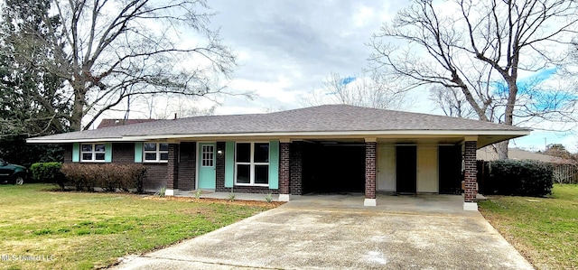 ranch-style home featuring driveway, brick siding, and a front yard