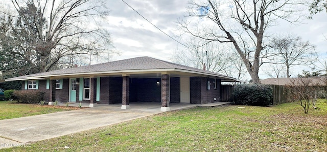 ranch-style home with driveway, a front lawn, roof with shingles, and brick siding