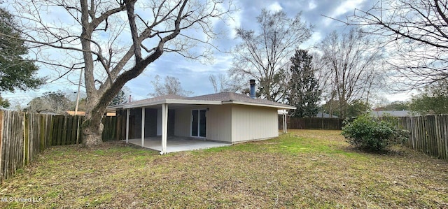 back of property featuring a fenced backyard, a patio, and a lawn