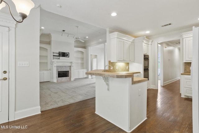 144 Whisper Lake Blvd, Madison, MS 39110 - kitchen with ceiling fan, crown molding, a kitchen bar, white cabinets, and a peninsula
