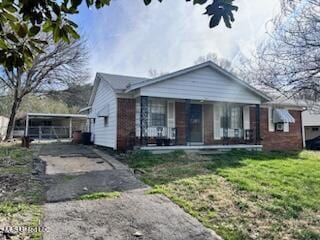 bungalow with covered porch, aphalt driveway, and a front yard