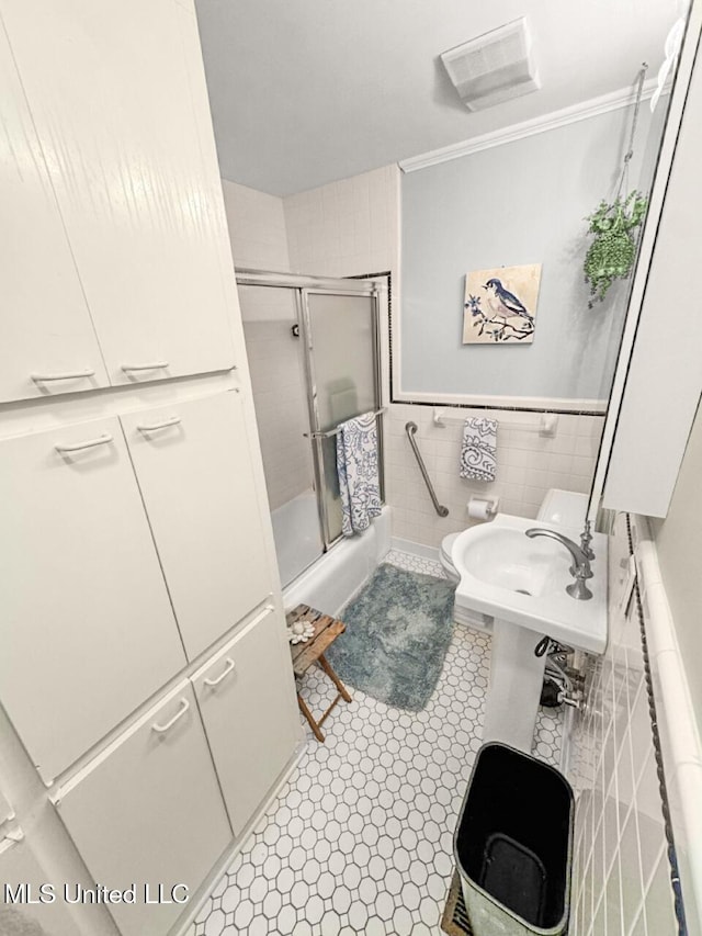 1802 Robinson St, Natchez, MS 39120 - full bath with crown molding, a sink, combined bath / shower with glass door, tile walls, and visible vents