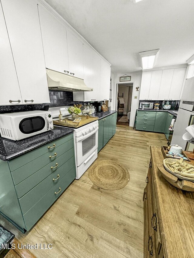1802 Robinson St, Natchez, MS 39120 - kitchen with under cabinet range hood, dark countertops, white range with gas stovetop, light wood-style flooring, and white cabinetry