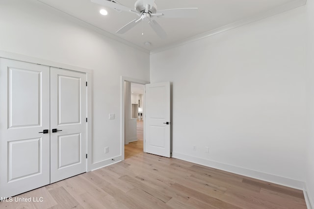 unfurnished bedroom with a closet, crown molding, light wood-type flooring, and ceiling fan