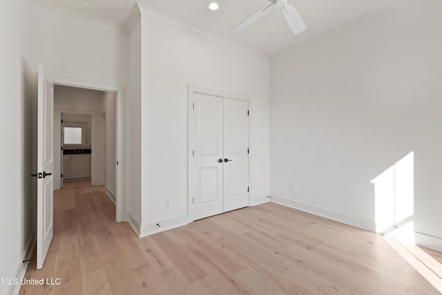 unfurnished bedroom with crown molding, light hardwood / wood-style flooring, a closet, and ceiling fan