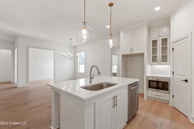 kitchen featuring a kitchen island with sink, sink, white cabinets, and stainless steel appliances