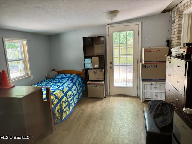 900 Orange St, Ocean Springs, MS 39564 - bedroom featuring wood finished floors, multiple windows, access to outside, and a textured ceiling