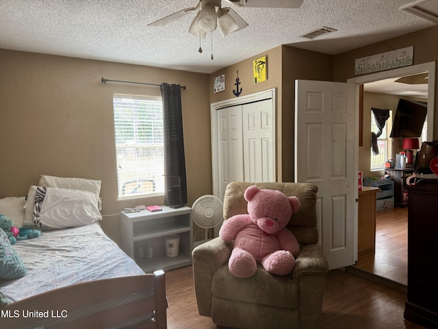 900 Orange St, Ocean Springs, MS 39564 - bedroom featuring wood finished floors, a textured ceiling, ceiling fan, and a closet