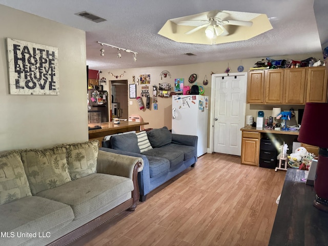900 Orange St, Ocean Springs, MS 39564 - living area featuring ceiling fan, light wood finished floors, and a textured ceiling