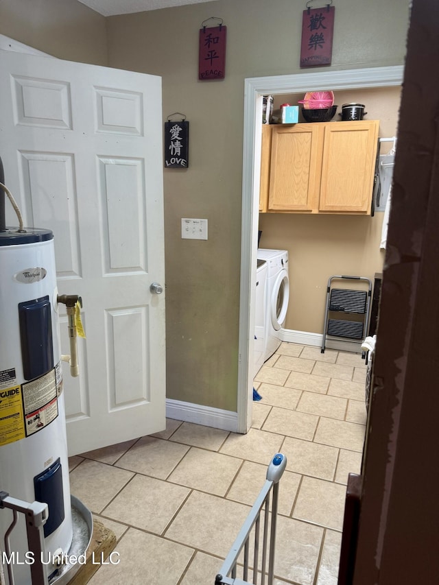 900 Orange St, Ocean Springs, MS 39564 - washroom with water heater, cabinet space, washer and dryer, light tile patterned floors, and baseboards