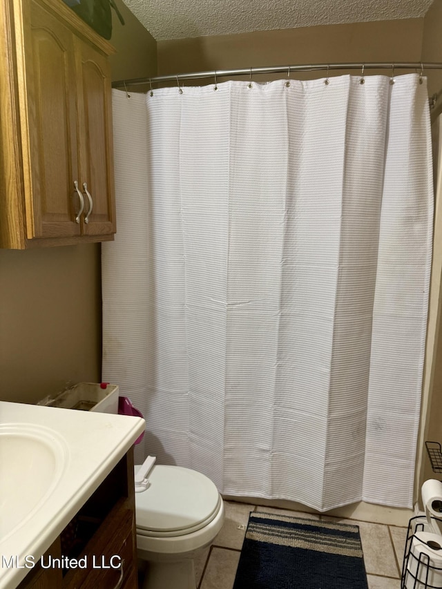 900 Orange St, Ocean Springs, MS 39564 - full bath featuring tile patterned flooring, vanity, toilet, a textured ceiling, and a shower with shower curtain