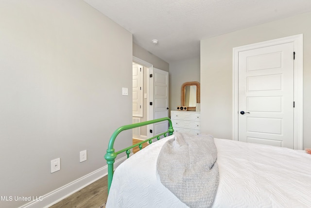 bedroom featuring wood finished floors and baseboards