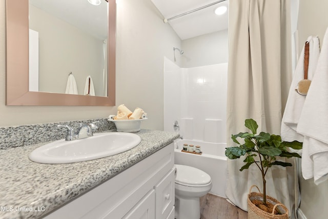 full bath featuring toilet, wood finished floors, vanity, and shower / bath combination with curtain