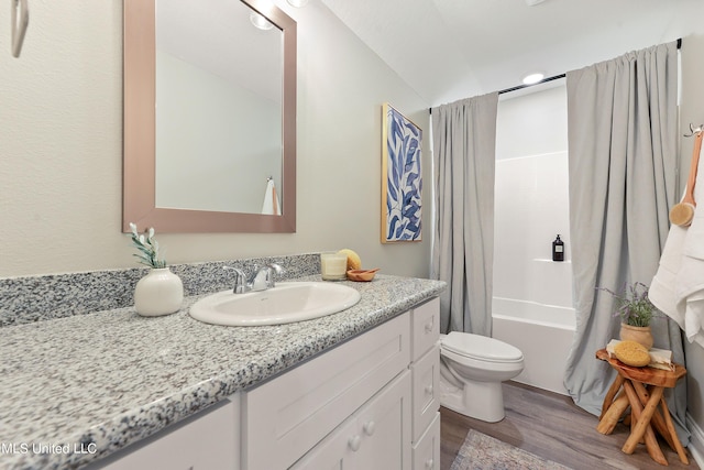bathroom with wood finished floors, toilet, vanity, and shower / bathtub combination with curtain