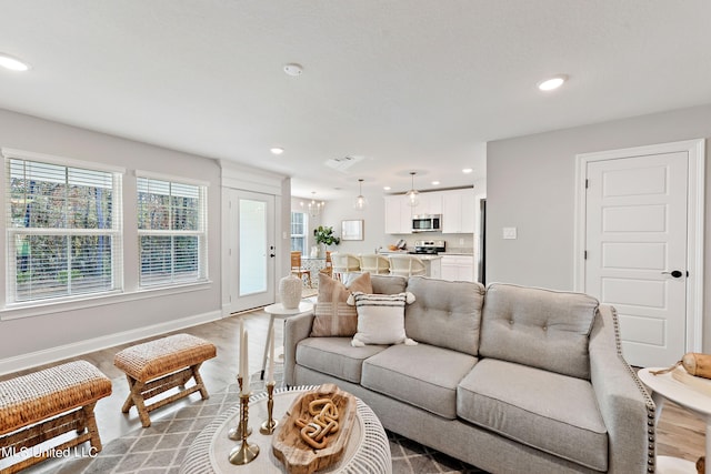living area featuring light wood-style floors, recessed lighting, and baseboards