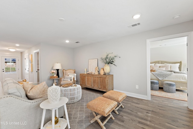 living room with wood finished floors, baseboards, and recessed lighting