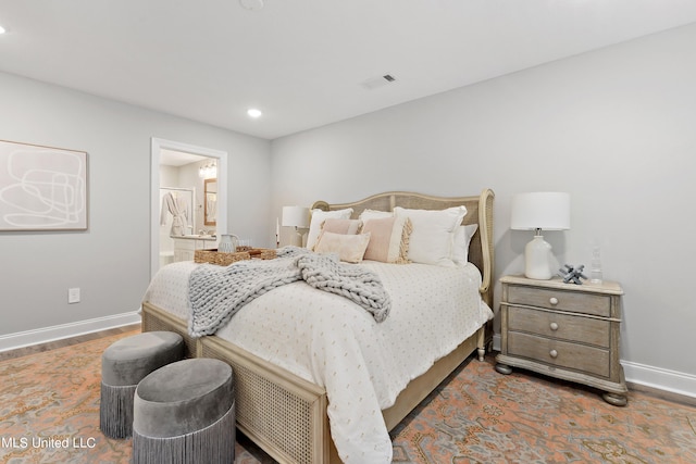 bedroom with baseboards, recessed lighting, and connected bathroom