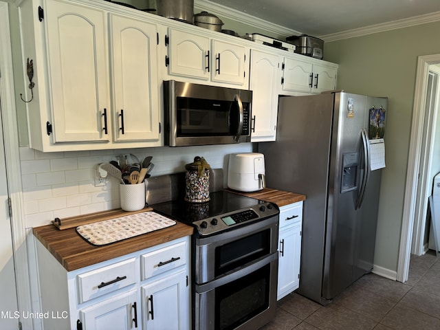 kitchen with butcher block countertops, white cabinetry, crown molding, and appliances with stainless steel finishes