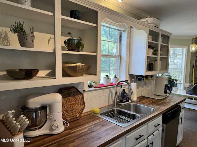 kitchen with stainless steel dishwasher, white cabinetry, butcher block counters, and sink