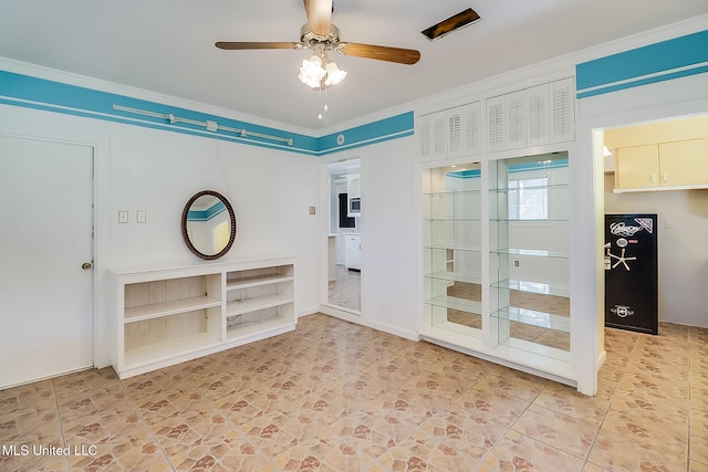 interior space with ceiling fan and ornamental molding