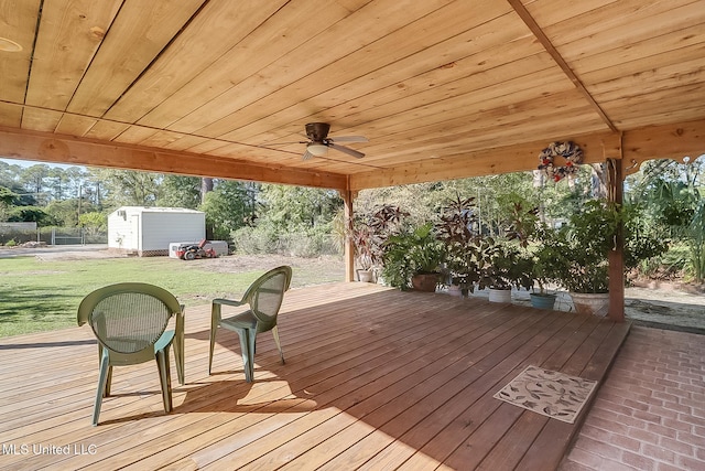 wooden deck featuring a yard and a storage shed