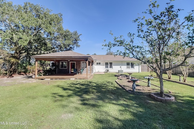 rear view of house featuring a lawn and a wooden deck