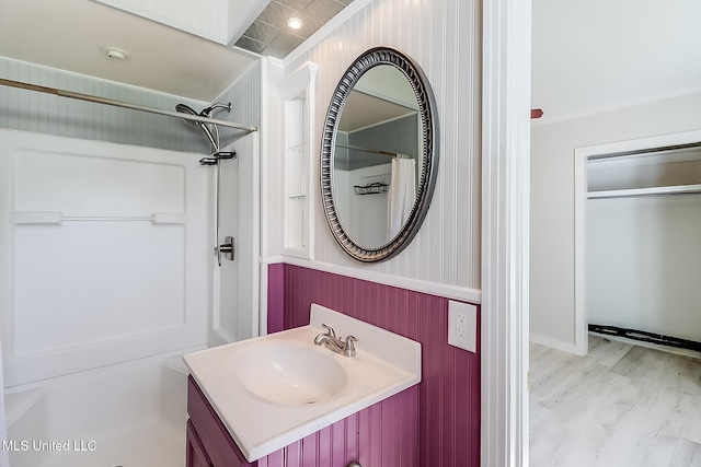 bathroom featuring hardwood / wood-style floors, vanity, curtained shower, and crown molding