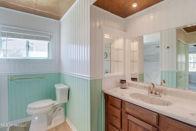 bathroom with vanity, toilet, and ornamental molding