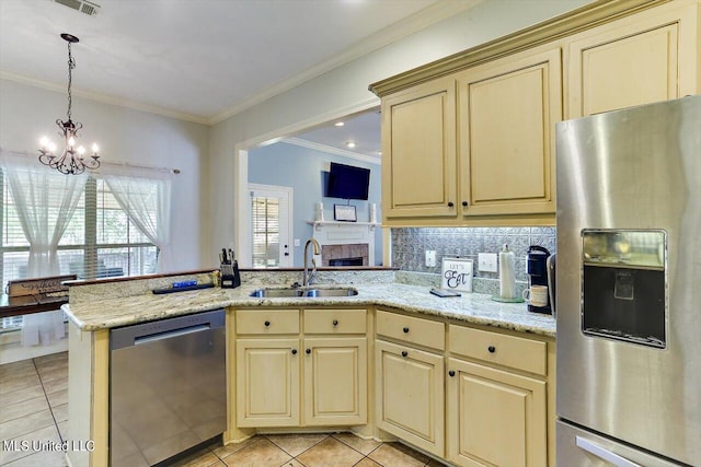 kitchen with sink, kitchen peninsula, stainless steel appliances, crown molding, and a chandelier