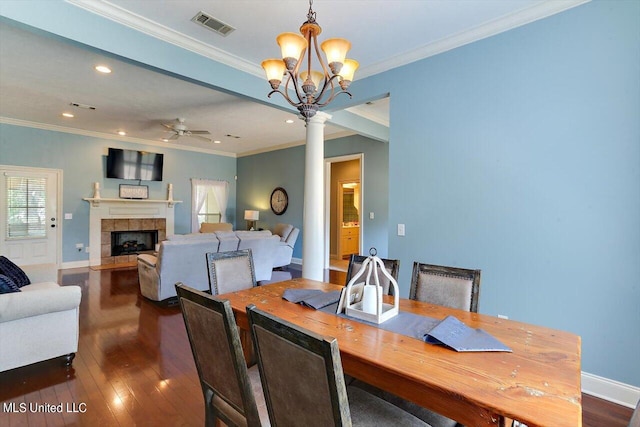 dining space with ornamental molding, dark wood-type flooring, and ornate columns