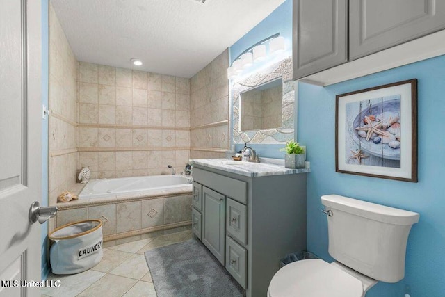 842 Deer Dr, Bay Saint Louis, MS 39520 - bathroom with tile patterned flooring, tiled bath, toilet, vanity, and a textured ceiling
