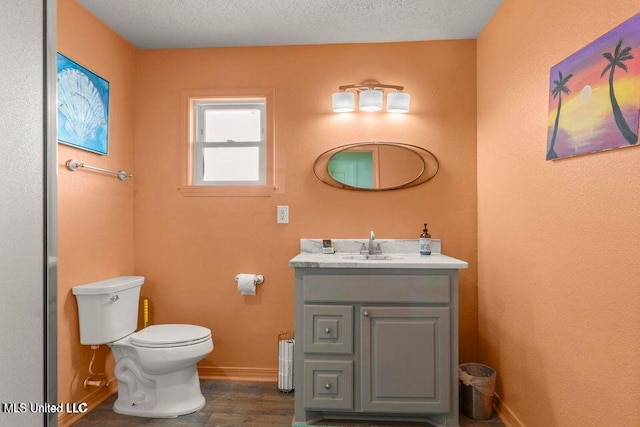 842 Deer Dr, Bay Saint Louis, MS 39520 - bathroom featuring baseboards, toilet, wood finished floors, vanity, and a textured ceiling