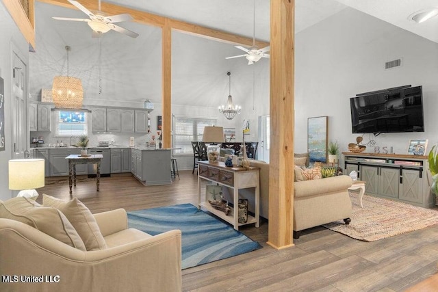 842 Deer Dr, Bay Saint Louis, MS 39520 - living room with high vaulted ceiling, a ceiling fan, a chandelier, light wood-type flooring, and plenty of natural light
