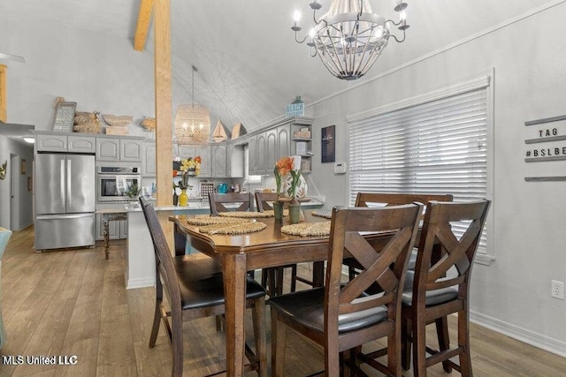 842 Deer Dr, Bay Saint Louis, MS 39520 - dining space featuring a chandelier, light wood-style flooring, lofted ceiling, and baseboards