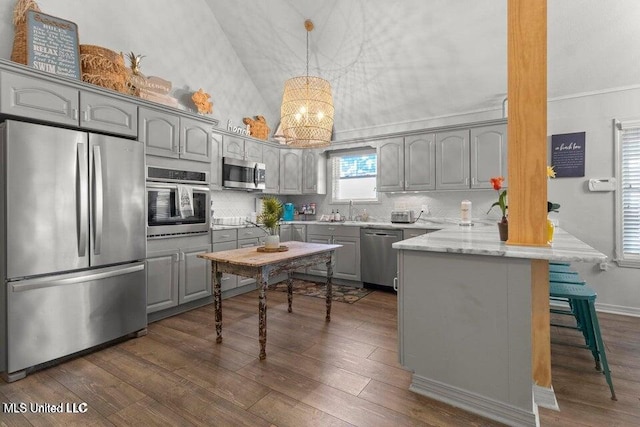842 Deer Dr, Bay Saint Louis, MS 39520 - kitchen featuring stainless steel appliances, gray cabinets, a peninsula, a chandelier, and lofted ceiling