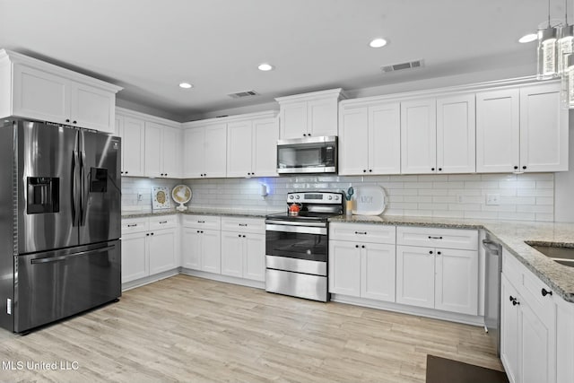 kitchen with stainless steel appliances, light wood-style flooring, visible vents, and white cabinets