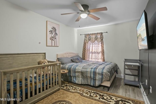 bedroom with wood finished floors, a ceiling fan, and baseboards