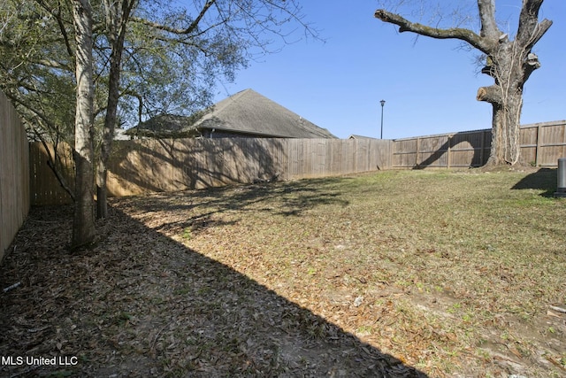 view of yard with a fenced backyard and central air condition unit