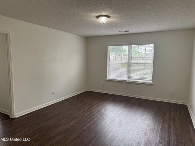 7413 Fox Creek Dr, Olive Branch, MS 38654 - spare room featuring visible vents, a textured ceiling, dark wood finished floors, and baseboards