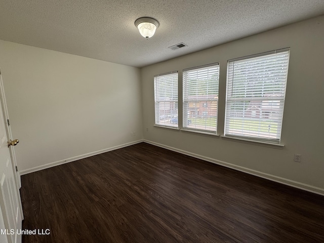 7413 Fox Creek Dr, Olive Branch, MS 38654 - unfurnished room with visible vents, a textured ceiling, dark wood finished floors, and baseboards
