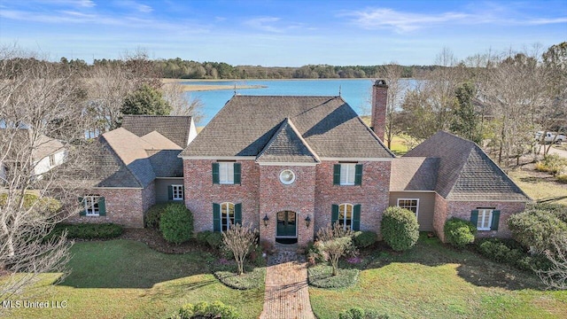 view of front of home with a front yard and a water view