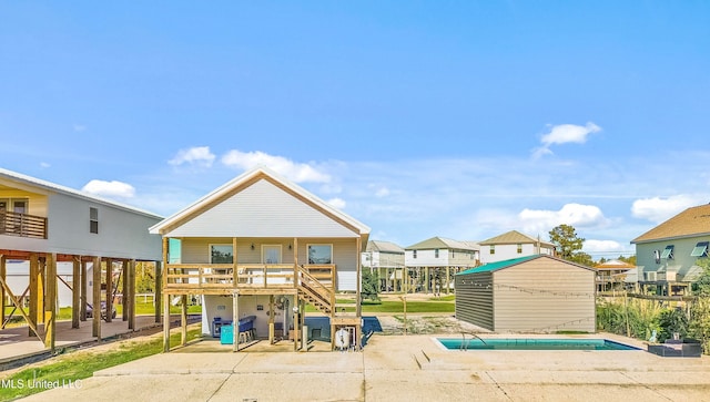 rear view of property with a storage unit