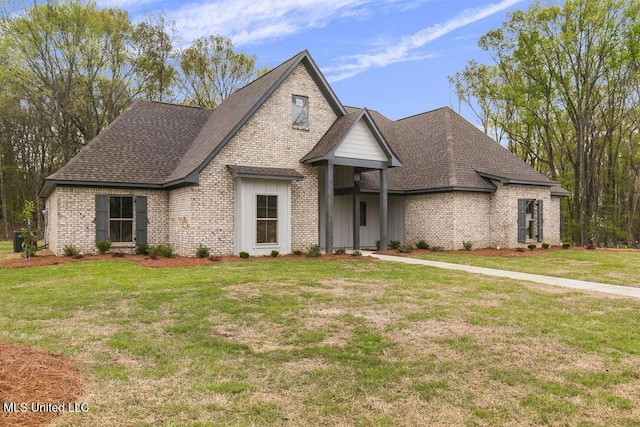 115 Grayson Way, Madison, MS 39110 - french country home featuring brick siding, a shingled roof, a front lawn, and board and batten siding