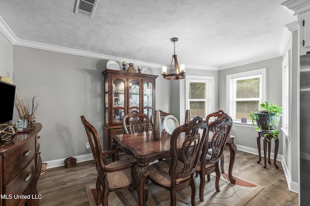 156 Cobbville Rd, Canton, MS 39046 - dining space featuring a chandelier, ornamental molding, wood finished floors, and a textured ceiling