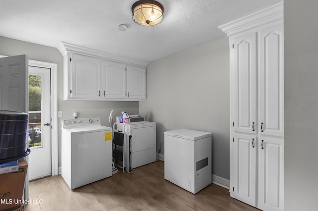 156 Cobbville Rd, Canton, MS 39046 - washroom featuring washer and clothes dryer, cabinet space, and light wood-style floors